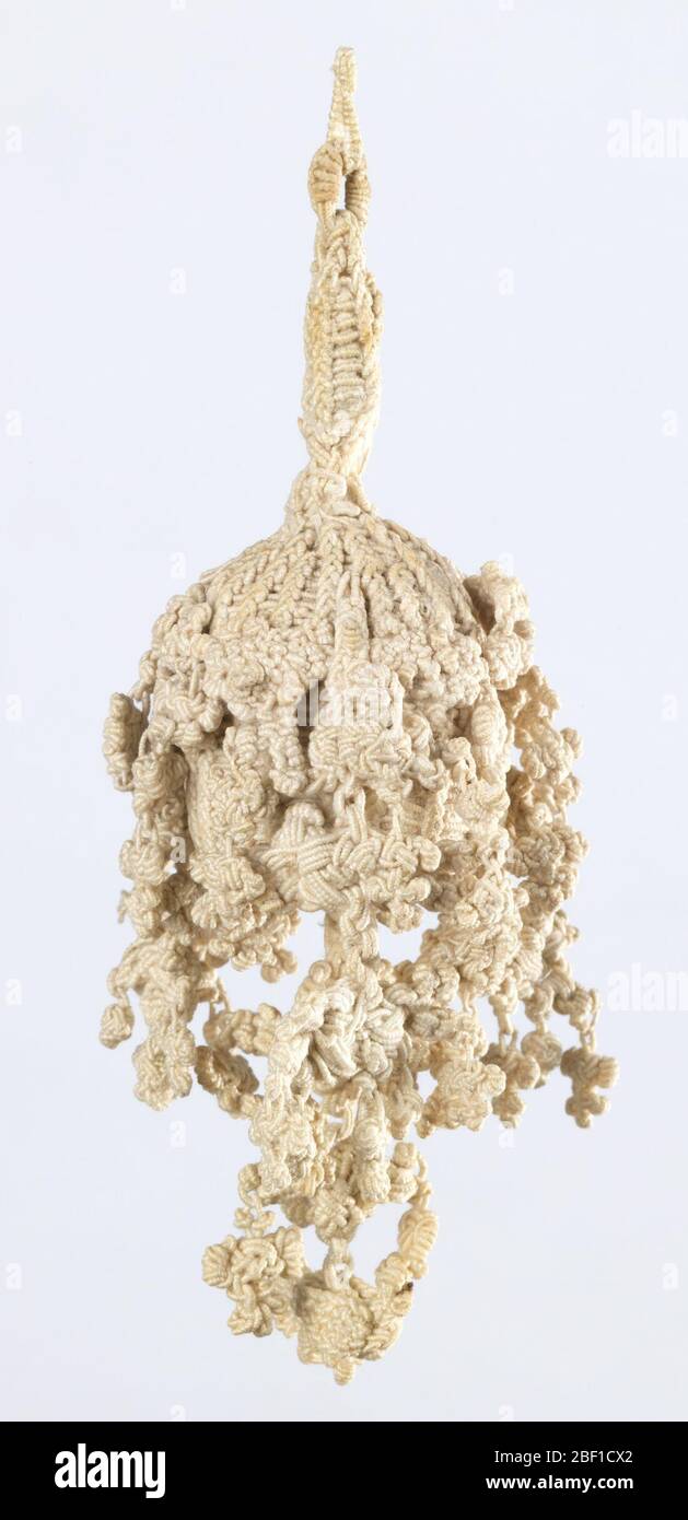 Quaste. Weiße Leinenquaste mit geflochtenem Stiel, der mit der eiförmigen Basis verbunden ist. Kern ist geflochten über und von ihm hängen mehrere verknotete Elemente - die längste von der Mitte. Stockfoto