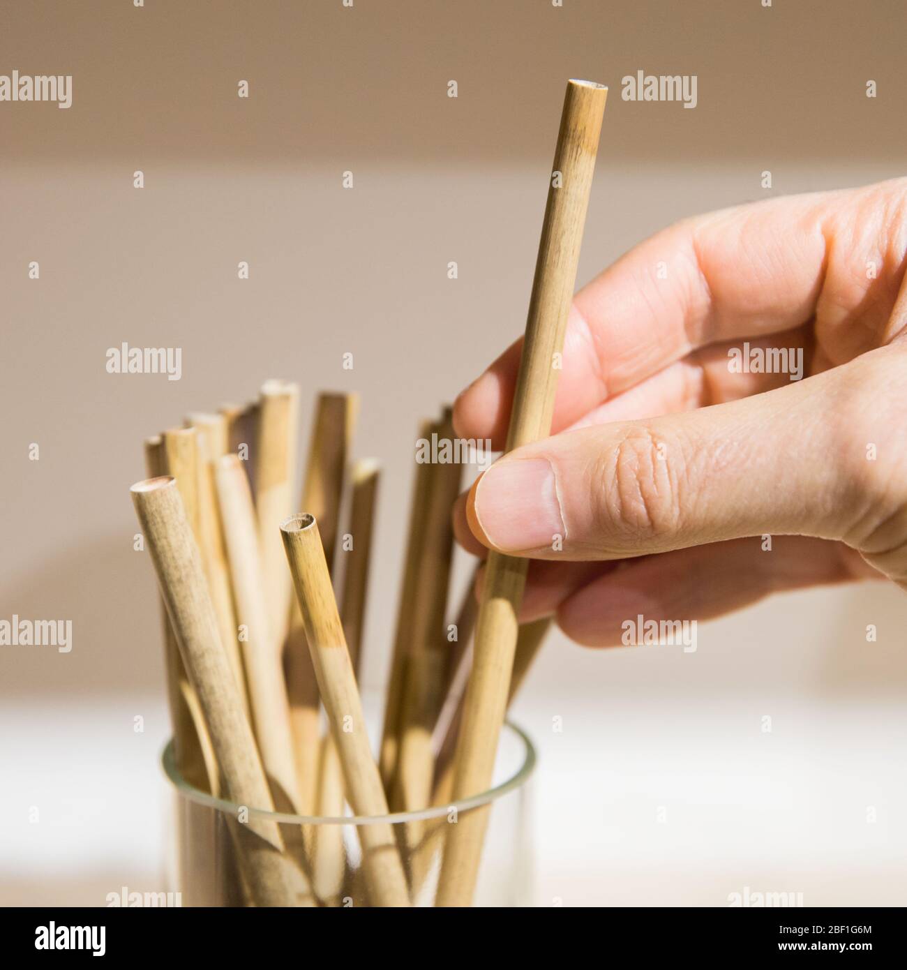 Austausch von Kunststoffhalmen. Mann Hand halten / berühren wiederverwendbare Stroh aus Bambus umweltfreundlich biologisch abbaubar, selektive weiche Fokus. Keine Verschwendung, keine Plasti Stockfoto