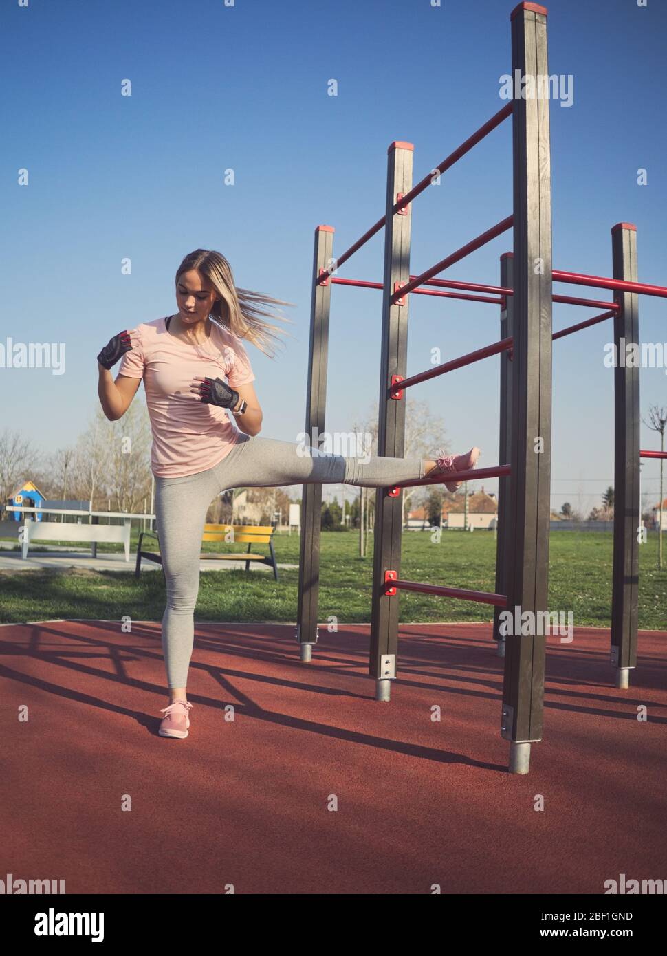 Junge Athletin Stretching Beine an der Wand Bars im Park Stockfoto