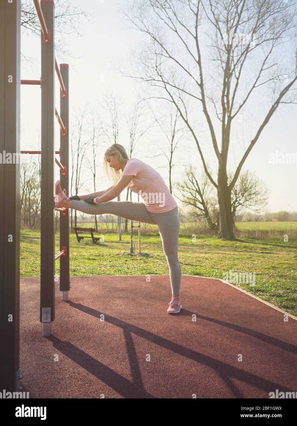 Junge Athletin Stretching Beine an der Wand Bars im Park Stockfoto