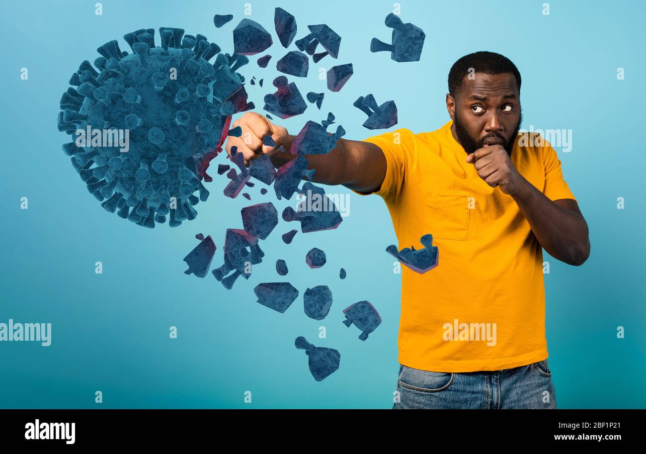 Der Mensch greift mit einem Schlag das Coronavirus an. Blauer Hintergrund Stockfoto