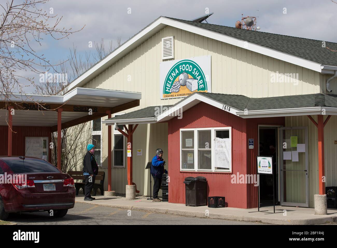 Helena, Montana - 16. April 2020: Zwei kaukasische Frauen mit Masken warten in Helena Food Share auf Lebensmittel, die während des Coronavirus benötigt werden. Stockfoto
