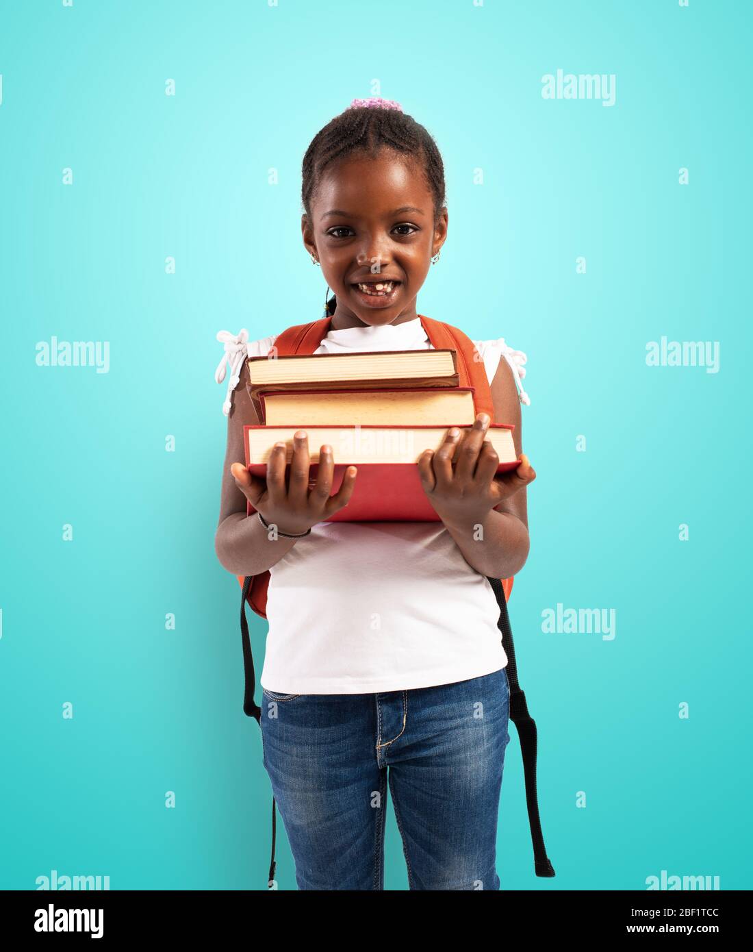 Das junge Mädchen hält ein Buch und ist bereit, zur Schule zu gehen Stockfoto