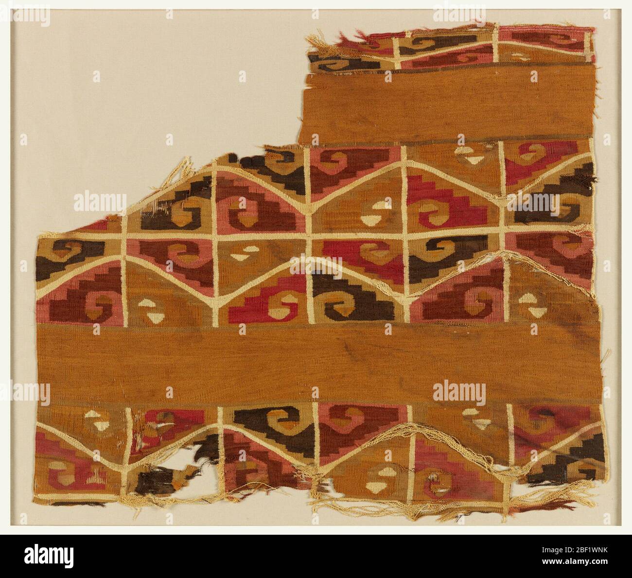 Tunika-Fragment. Ein Fragment mit geometrischen Figuren ist stark suggestiv von Tiwanaku IV (?) art. Der Hintergrund ist dunkel braun, das Design in hell braun, mittel und dunkelbraun, hellrot, rotbraun und lila rot. Stockfoto