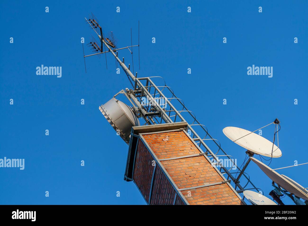 Telekommunikationsgeräte auf einem Ziegelkamin Stockfoto