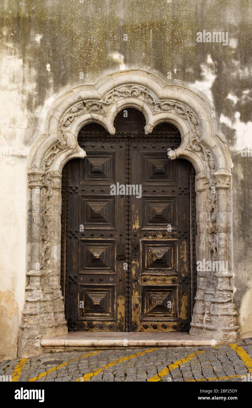 Der seitliche Eingang der Elvas Hauptkirche, Nossa Senhora da Assuncao, und ehemalige SE Kathedrale. Holz geschnitzte Tür von reichen Stein Schnitzwerk in M gerahmt Stockfoto