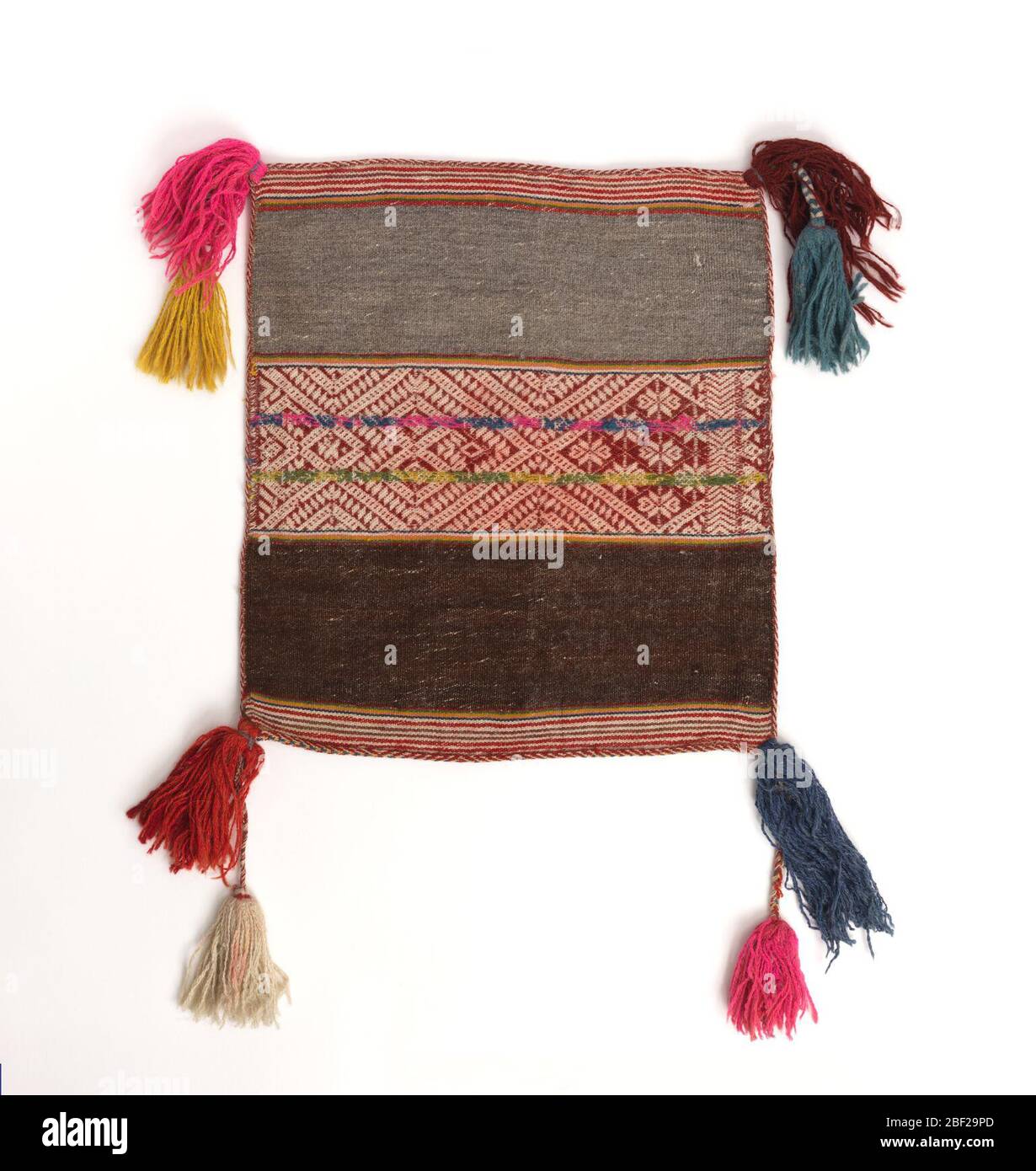 Tasche Gesicht für eine Chuspa. Tragetasche aus gewarptem, einfarbigem Webmuster in abwechselnden Streifen. Breite Streifen aus braun und grau flankierend ein Mittelstreifen mit geometrischem Muster in rot und weiß mit zwei überlagerten Bleistiftstreifen in rosa und blau, grün und gelb. Stockfoto
