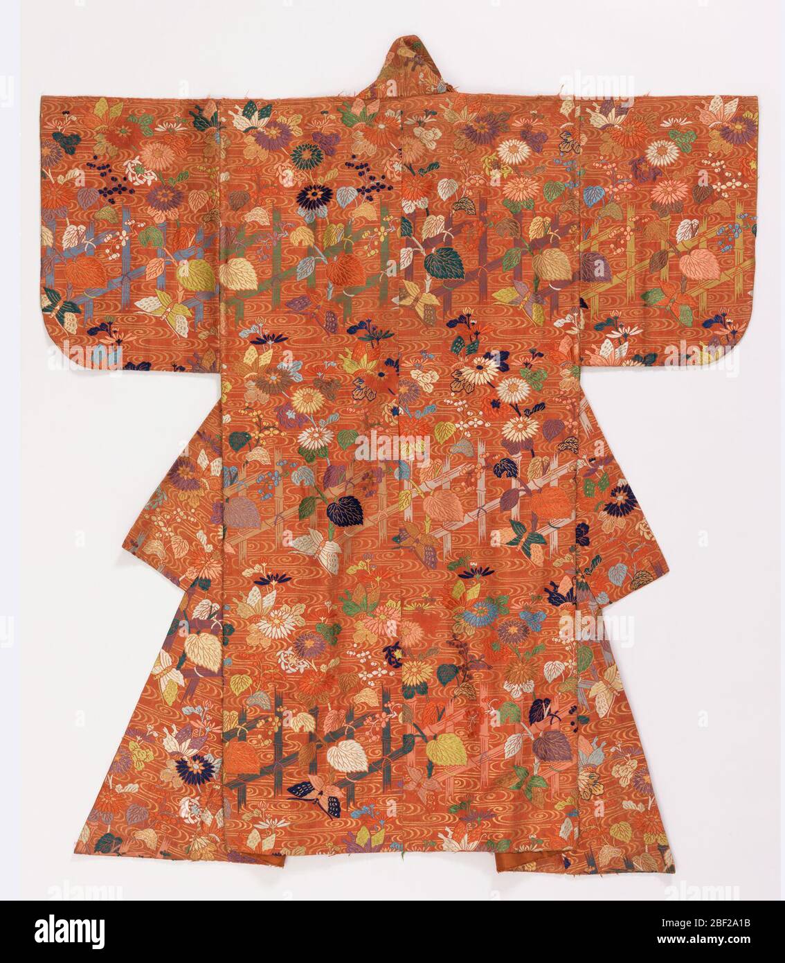 Noh Robe. Theatralische Robe aus Terrakotta-Seide Köperstoff, stark in polychromen Seide und vergoldeten Seidenkerngarnen brokat. Das Design ist aus Bambusgittern und Reben, Chrysanthemen, Beeren und Schmetterlingen. Mit einfarbiger Terrakotta-Seide gefüttert. Stockfoto