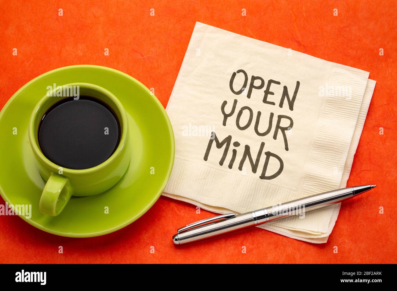 Öffnen Sie Ihren Geist inspirierende Note - Handschrift auf einer Serviette mit einer Tasse Kaffee, persönliches Wachstum, Selbstverbesserung und Entwicklung Konzept Stockfoto