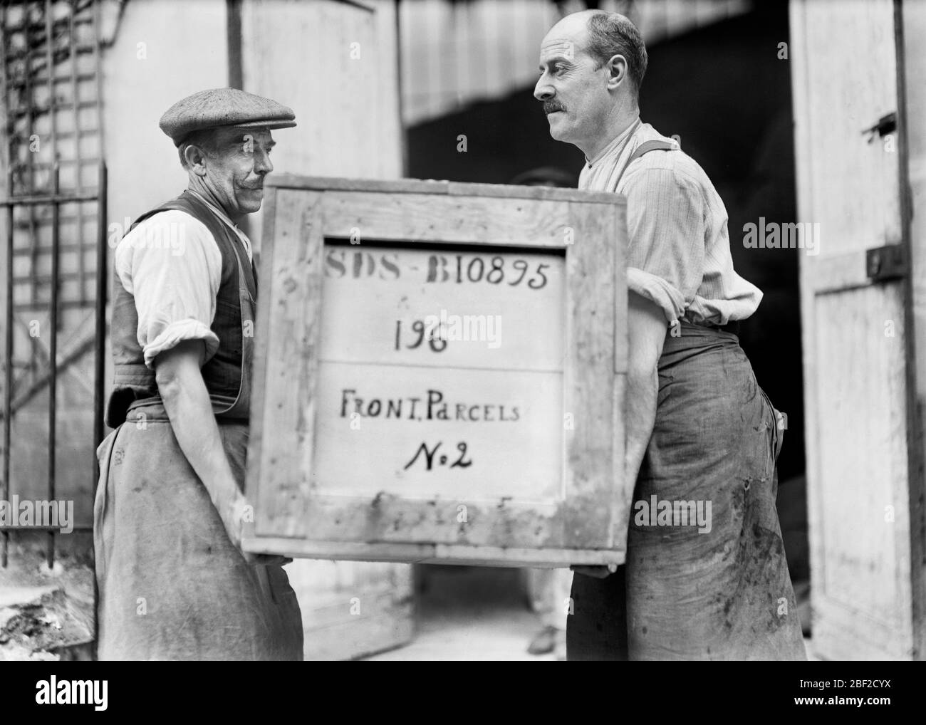 Zwei Männer mit einer Kiste mit Zubehör des amerikanischen Roten Kreuzes mit der Aufschrift "Front Parcels", die an die Front Lines of war, Frankreich, Lewis Wickes Hine, Photographensammlung des amerikanischen Roten Kreuzes, Juli 1918, geliefert werden soll Stockfoto