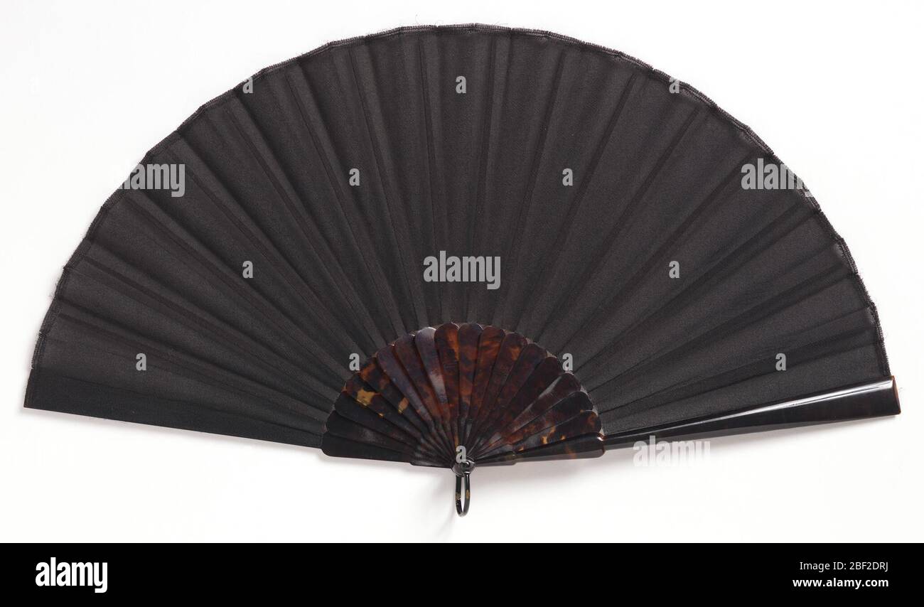 Gefaltettete Lüfter und Tasche. Gefaltelte Trauerfächerfächer Blatt aus schwarzer Georgette crêpe mit Organdy unterlegt. Schildpatt-Muschel-Sticks. Schwarz emaillierter Metallbügel. Schwarze Satin Box mit weißem Satin gefüttert und mit dem Aufschrift "Tiffany & Co." Stockfoto