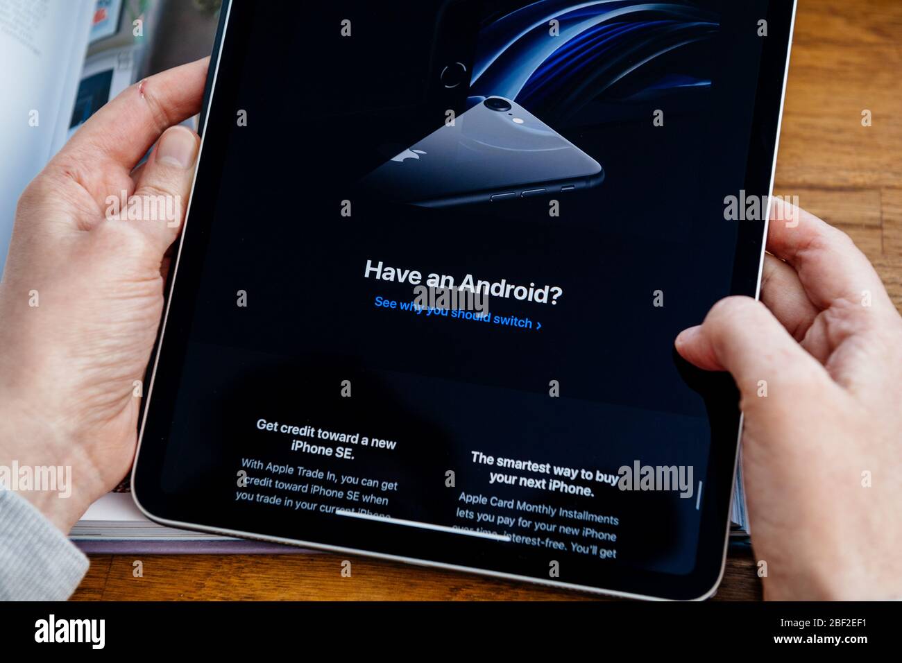 Paris, Frankreich - Apr 16, 2020: Frau auf der Apple Computers Internet-Website auf iPad Pro Tablet in Raum-Umgebung präsentiert neue iPhone SE mit Migration von Android OS Stockfoto