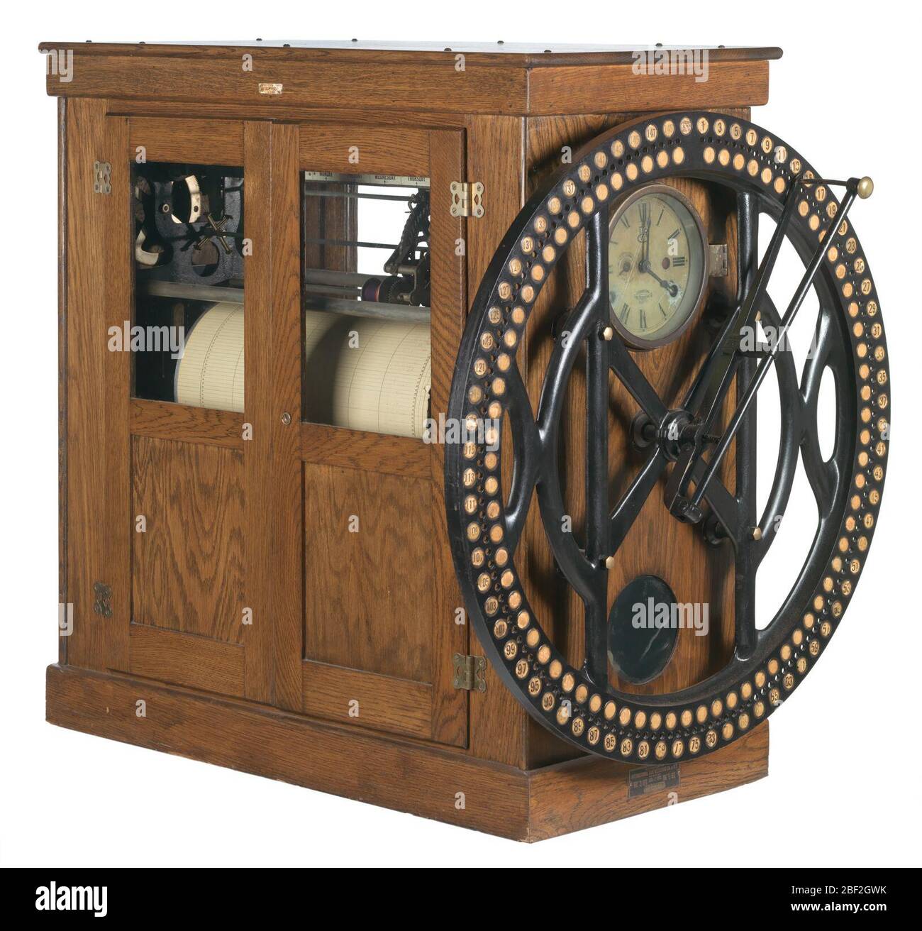 Zeituhr von der R H Boyd Publishing Corporation. Eine große rechteckige Arbeiterzeituhr, die von der R. H. Boyd Publishing Company verwendet wird. Die Vorderseite der Uhr hat ein großes Metallrad mit kleinen schwarzen eingekreisten Zahlen. Hinter dem großen Metallrad befindet sich eine Uhr mit römischen Ziffern und einem AM/PM-Zifferblatt. Stockfoto