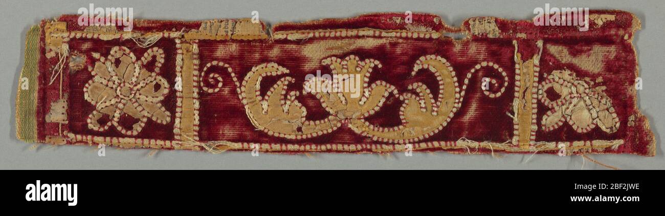 Fragment. Randfragment mit gelber Schriftrolle und Blatt appliziert auf rotem Samt. Stockfoto