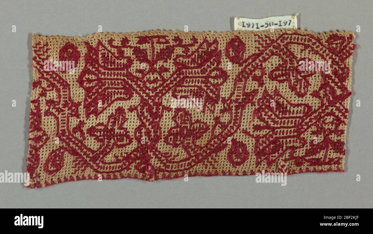 Fragment. Fragment einer Borte mit einem roten Blumenmuster Weinrebe auf Gaze Webart. Stockfoto