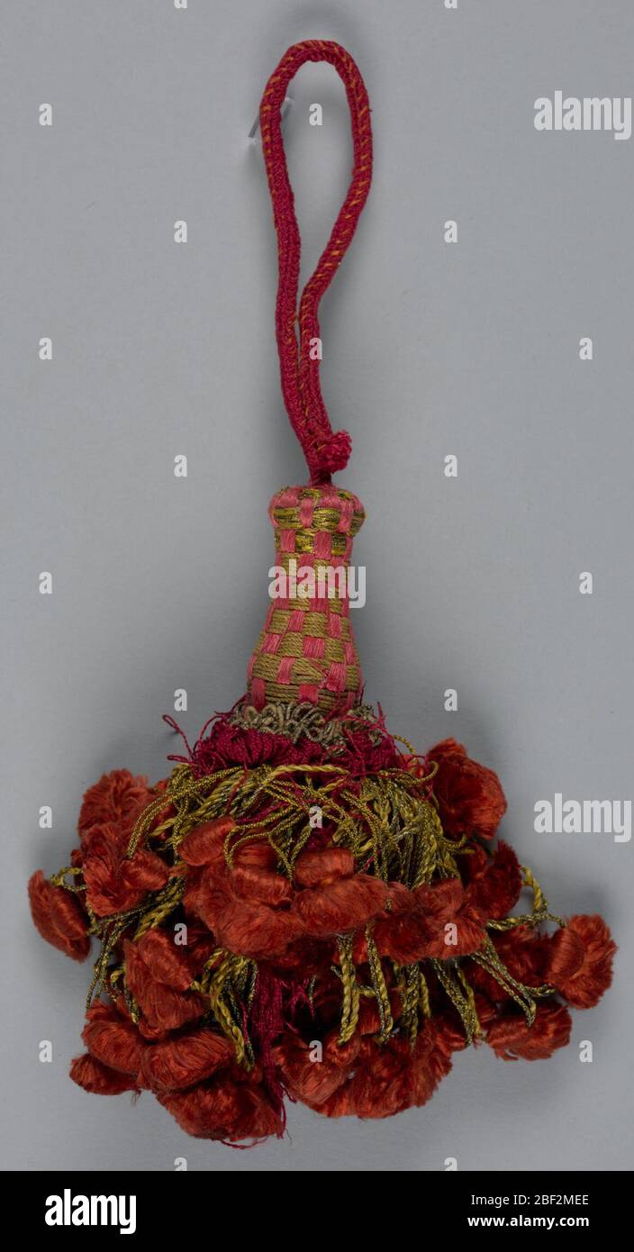Quaste. Rock aus roter Seide mit Metallfaden Schleife von zwei Längen bedeckt, die jeweils eine bräunlich-rote seidenige Quaste unterstützen. Kragen oben aus Seide und Metallschlaufen. Der Kopf ist mit rosa Seide und Metall im Schachbrettmuster bedeckt. Schlaufe aus roter Seidenschnur. Stockfoto