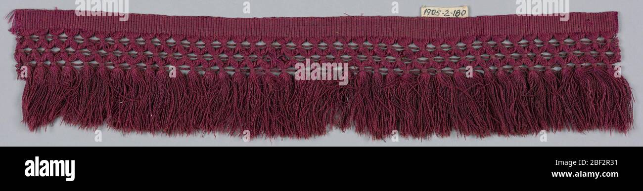 Fransen. Rote Franse mit einer einfarbigen Webüberschrift, Band im Spaliermuster und Rockfäden. Stockfoto