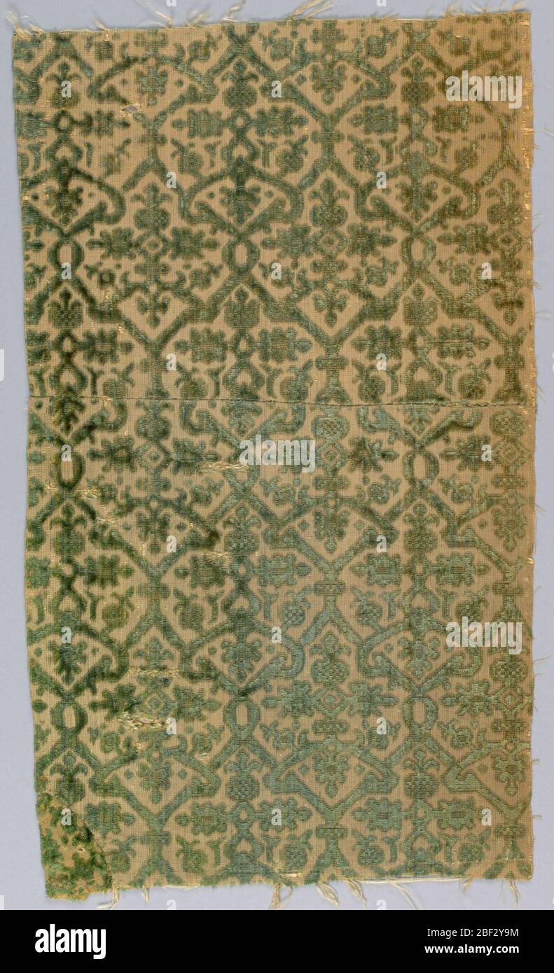 Fragmente. Zwei kleine Fragmente aus grünem Samt mit geschnittenen und ungeschnittenen Flor auf cremefarbenem Grund. Muster ist ein verflochtenes Gitter, das kleinformatierte Pflanzengestaltung umschließt. Stockfoto