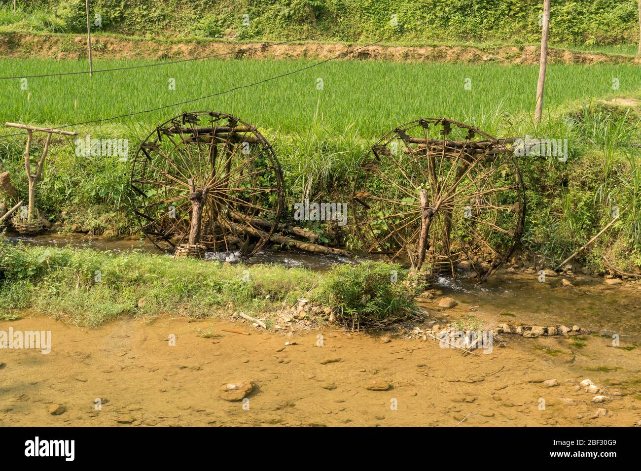 Wasserräder, die die Schwerkraft antreiben, führen die Bewässerung für die Reisterrassen im Pu Luong Nature Reserve, Vietnam Stockfoto