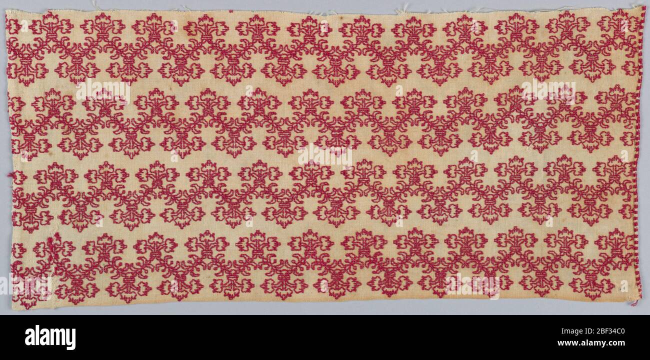 Fragment. Weißer Leinenschlick mit roter Seidenstickerei in horizontalen Zickzack-Linien, symmetrisches, dreistämmiges, konventionalisiertes Blumenmuster. Stockfoto