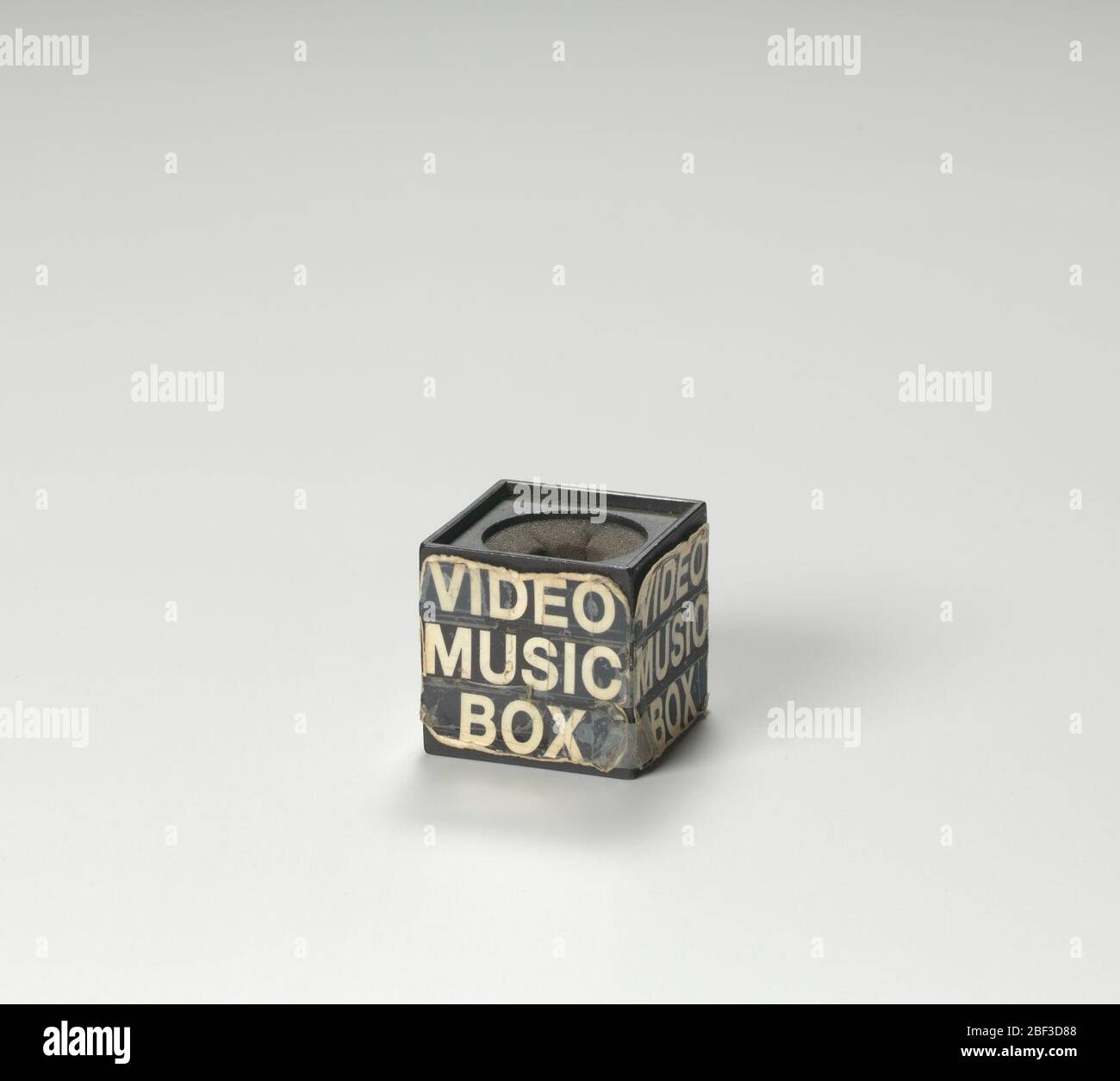 Mikrofonbox, die von Ralph McDaniels in der Fernsehshow Video Music Box verwendet wird. Eine würfelförmige schwarze Mikrofonbox, die auf dem Fernseher verwendet wird, zeigt die Video Music Box. Die Mikrofonbox hat einen kreisförmigen Ausschnitt durch die Mitte oben und unten am Würfel. Das Innere des Würfels ist mit dunkelgrauem Schaum ausgekleidet. Stockfoto