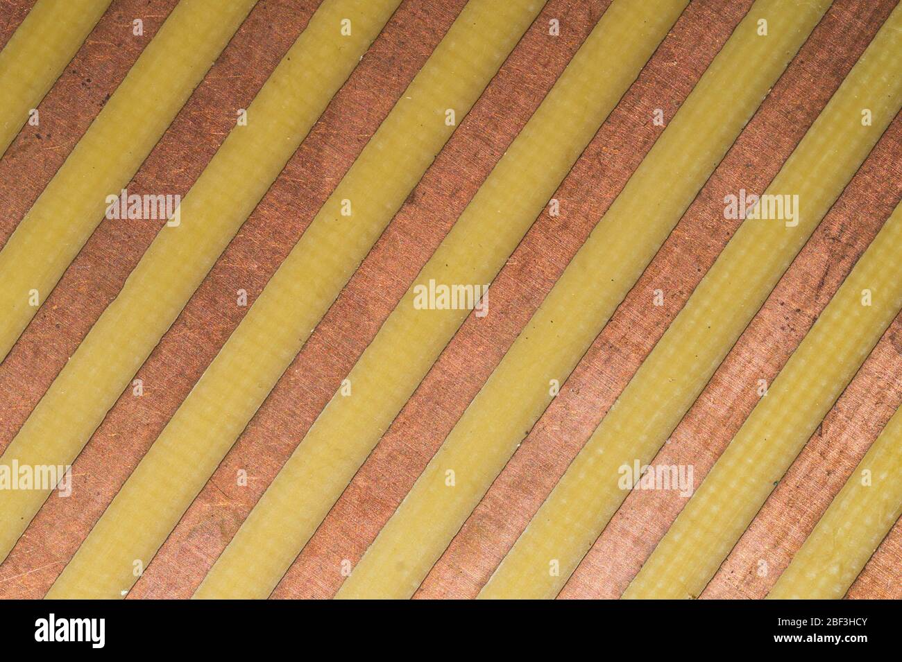Parallele Kupferbahnen auf dem Stromkreis Nahaufnahme. Industrieller Hintergrund. Metalloberfläche Stockfoto