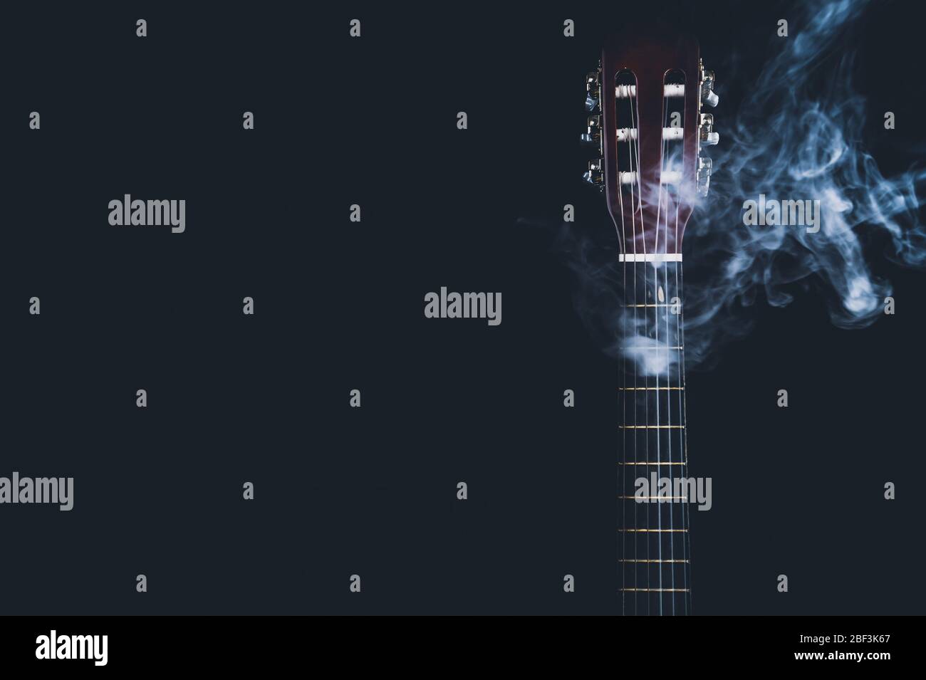 Gitarre im Rauch auf schwarzem Hintergrund. Akustisches Musikinstrument. Saiten am Gitarrenhals Stockfoto