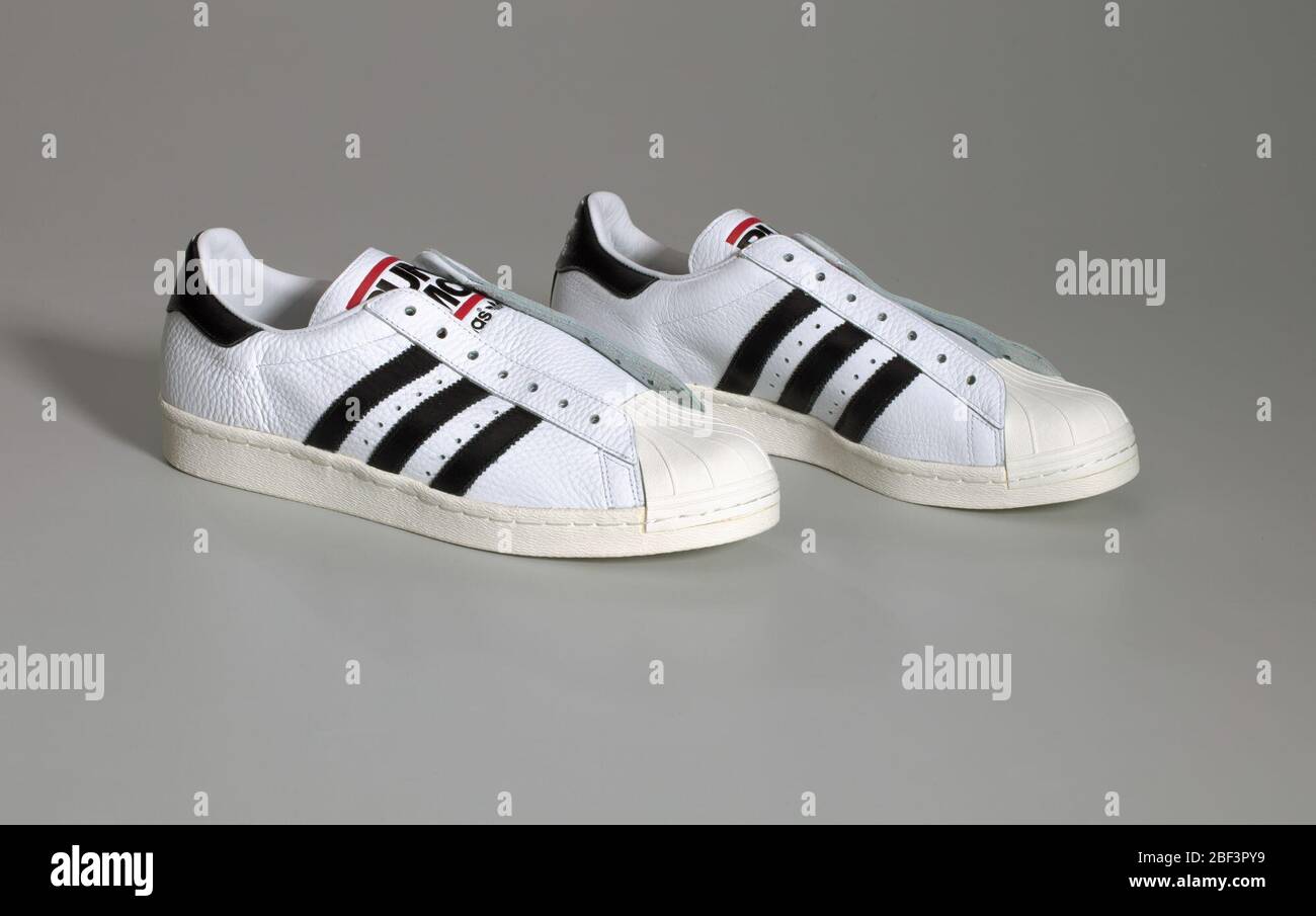 Ein Paar weiße und schwarze RunDMC Superstar 80s Sneaker von Adidas. Ein  Paar weiße Run-D.M.C. Adidas Schuhe (.1ab), ein Paar schwarze fette  Schnürsenkel (.2ab), ein Paar weiße Schnürsenkel (.3ab) und die  Original-Schuhbox