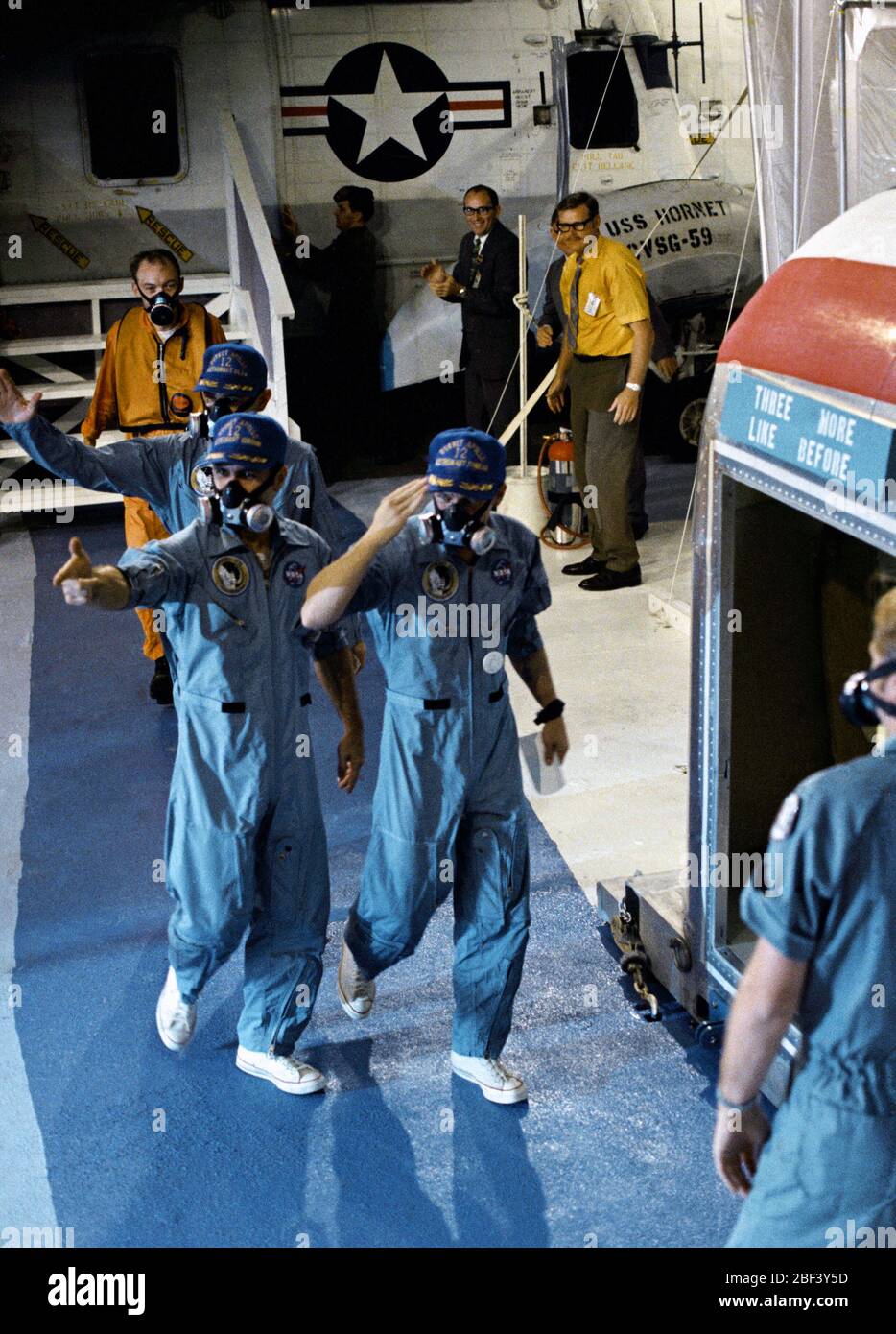 (24 Nov. 1969)------- USS Hornet Besatzungsmitglieder sind von der Besatzung von Apollo 12 Mondlandung Mission als die drei Astronauten begrüßt werden von einem US-Marine Hubschrauber zu einem mobilen Quarantäneeinrichtung (von monolithischen Quarzfiltern) an Bord der Prime recovery Schiff übertragen. Charles Conrad jr., rechts, Commander; Richard F. Gordon jr., Befehl Modul Pilot, links vorne; und Alan L. Bean, Lunar Module Pilot, spritzte sicher um 2:58 Uhr, Nov. 24, 1969. Stockfoto