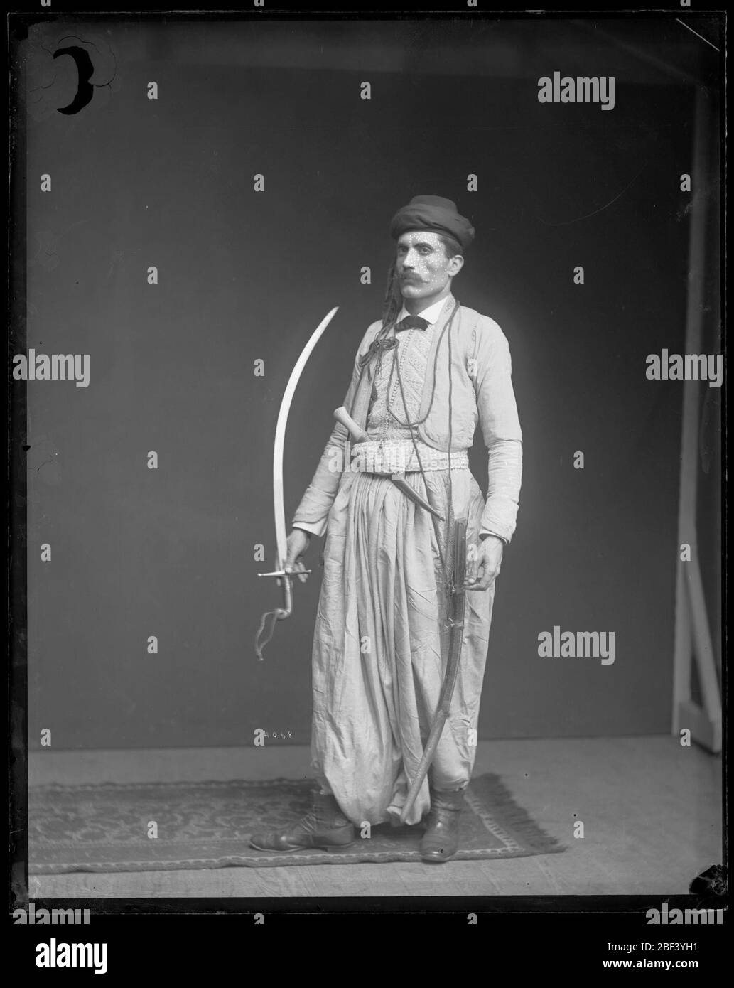 Fares EIN Ferzan-Modell Syrian Kostüm mit Schwert und Dolch. Fares A. Ferzan vom Libanonberg in Syrien war ein Ladenbesitzer in Atlantic City, der in den 1880er Jahren zu verschiedenen Ausstellungen reiste, wo er feine Seidenwebetechniken vorführte. Stockfoto