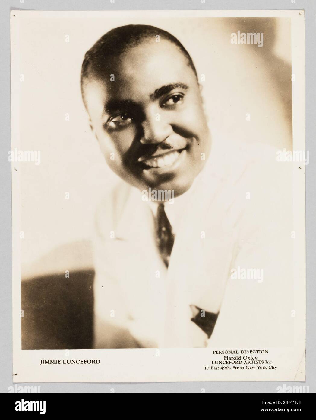 Foto von Jimmie Lunceford. Ein Silbergelatinedruck, der ein Schwarz-Weiß-Bild von Jimmie Lunceford zeigt. Er ist in drei Viertel Profil dargestellt, in Büste Pose, Blick auf die rechte Seite des Bildes. Er trägt eine weiße Jacke, ein weißes Hemd und eine Krawatte mit dunklem Muster und ein Taschenquadrat. Stockfoto