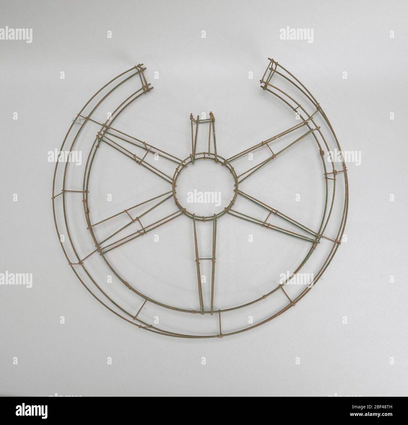 Drahtrahmen gebrochen Rad. Einige der beliebtesten Entwürfe in Beerdigung Blumen im späten neunzehnten Jahrhundert waren diejenigen, die auf die Sentimentalität der Zeit appellierte. Diese Blumenrahmen Designs waren sowohl dekorativer als auch persönlicher in ihren Referenzen. Stockfoto