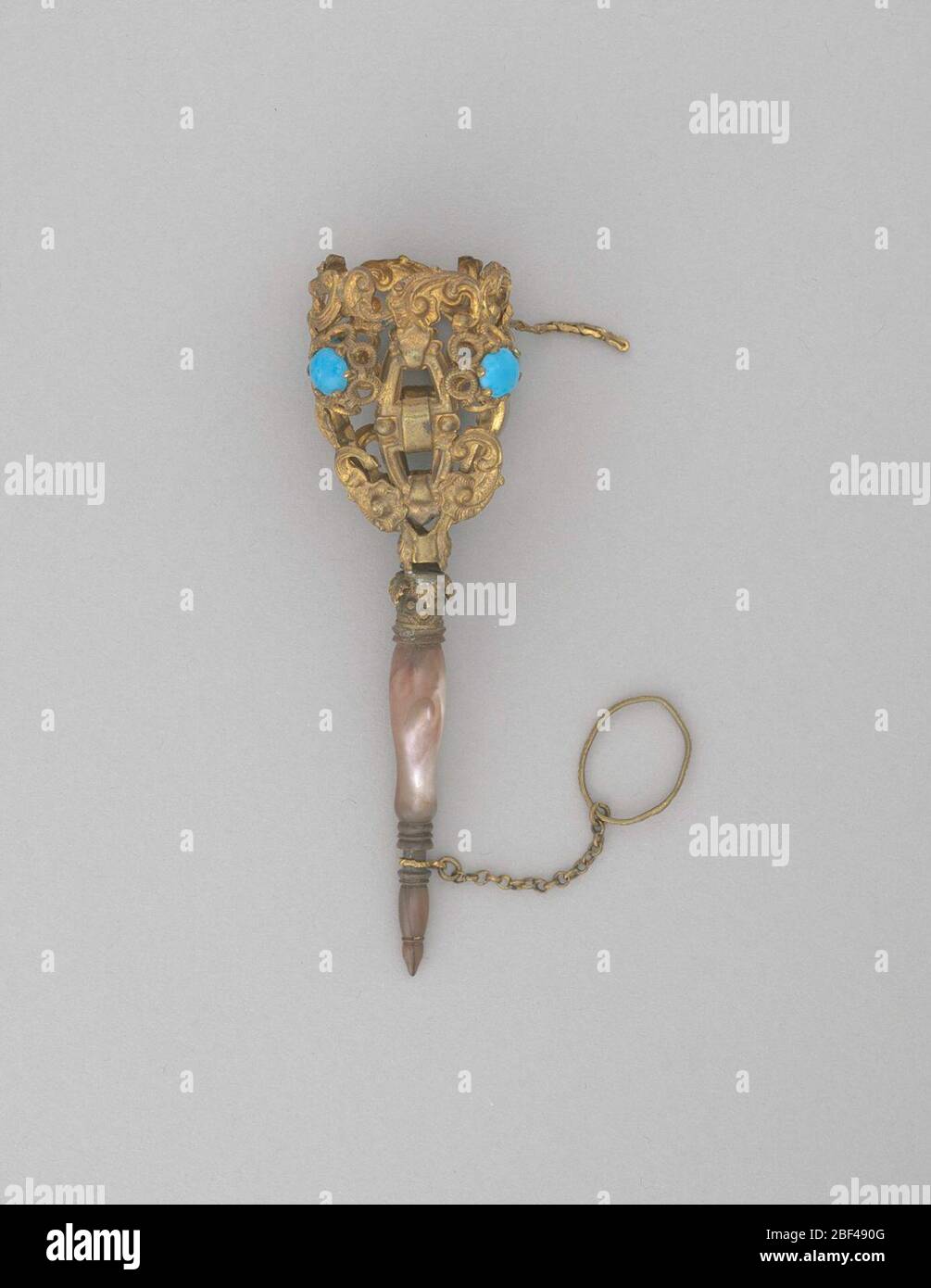 Blumenstraußhalter blaue Steine Perlmutt. Vergoldete Messingvase mit blauen Steinen. Die Vase des Blumenhalters ist mit vier sich wiederholenden Tafeln geformt. Jede Tafel ist kunstvoll mit ‘S' und ‘C' Schriftrollen gestaltet und mit einem blauen Pastenstein verziert, der auf einem Ring aus Kreisen gesetzt ist, die jeden einzelnen anheben. Stockfoto