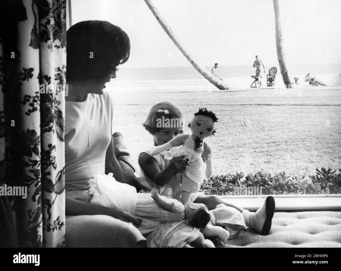 First Lady der Vereinigten Staaten JACQUELINE KENNEDY Tochter CAROLINE KENNEDY. Präsident John F. KENNEDY kann in der Ferne am Strand gesehen werden. Stockfoto