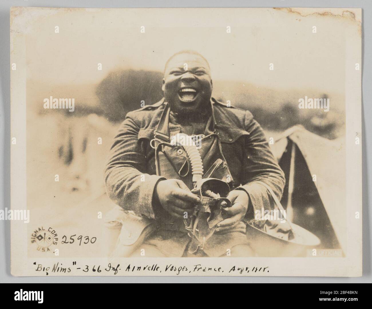Big Nims 366 Inf Ainvelle Vosges Frankreich 8. August 1918. Dieses Foto zeigt einen Mann in der Mitte lachen. Sein Helm hängt vom linken Unterarm ab und er hält eine Gasmaske in den Händen. Hinter ihm steht rechts auf dem Foto ein Zelt. Das Logo des Signal Corps USA erscheint in der linken unteren Ecke. Stockfoto
