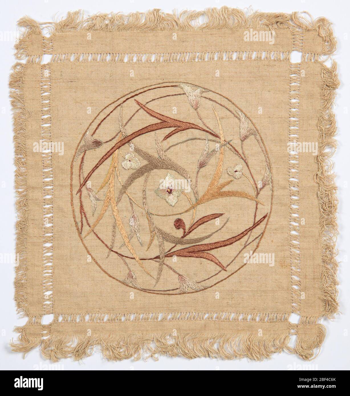 Doily. Deckchen bestickt in einem runden, floralen Jugendstil-Muster mit mehrfarbigem Seidenfaden. Stockfoto