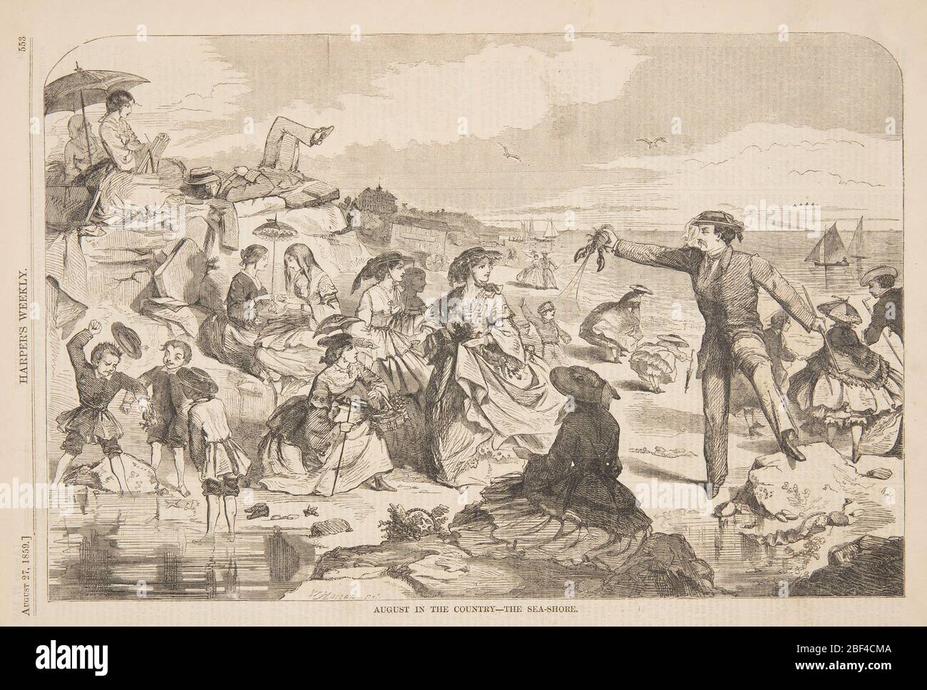 August auf dem Land die Küste. Figuren an einem überfüllten Strand. Ein Mann hält einen lebenden Hummer. Stockfoto