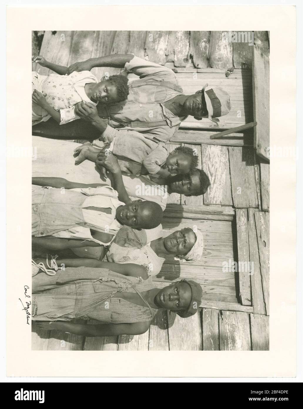 Rehabilitationskunde und seine Familie auf Ladys Island vor Beaufort SC. Ein Silbergelatine-Print einer schwarzen Familie in South Carolina. Die drei Erwachsenen stehen am weitesten von der Kamera entfernt; (von links nach rechts) der Vater, die Mutter und die Großmutter der Familie. Stockfoto