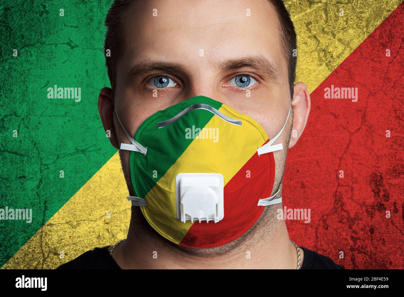 Junger Mann mit Wunden Augen in einer medizinischen Maske in den Farben der Nationalflagge der Republik Kongo gemalt. Coronovirus-Krankheit COVID-19 Konzept. Stockfoto