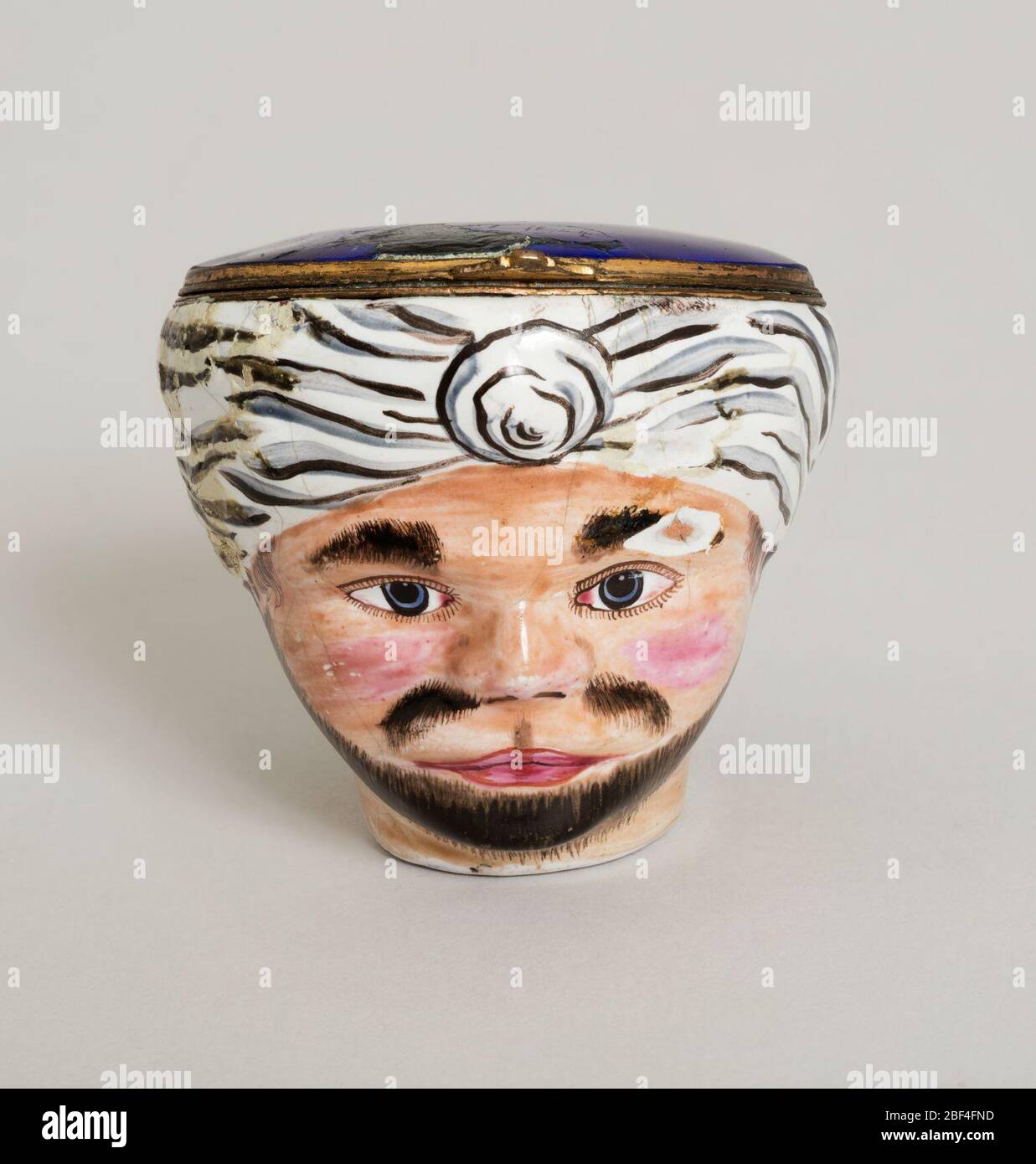 Feld. In Form eines Kopfes; Feld aus weißem Emaille, mit den Besonderheiten gefärbt. Klappdeckel und dunkelblau auf der Außenseite. Darstellung eines 'Türkischen'. Stockfoto