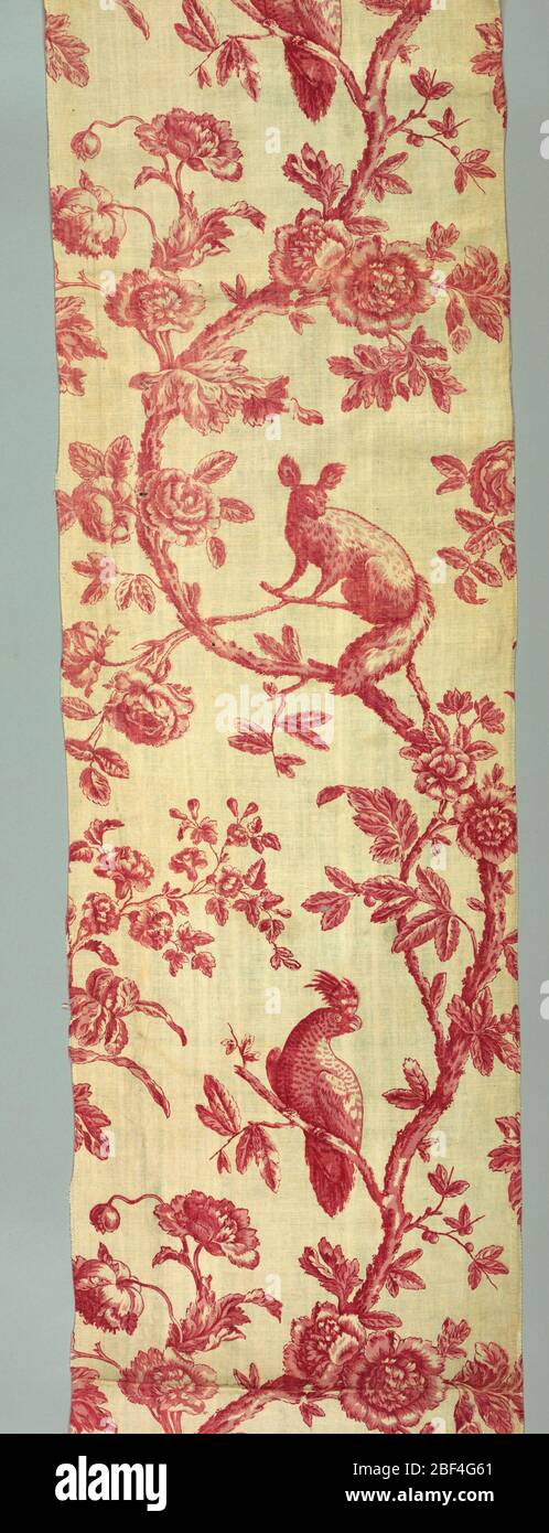 Textil. Rote und weiße Toile mit einem Muster von zwei geschwungenen blühenden Bäumen. Jeder Baum hat ein Eichhörnchen und einen exotischen Vogel darauf. Stockfoto