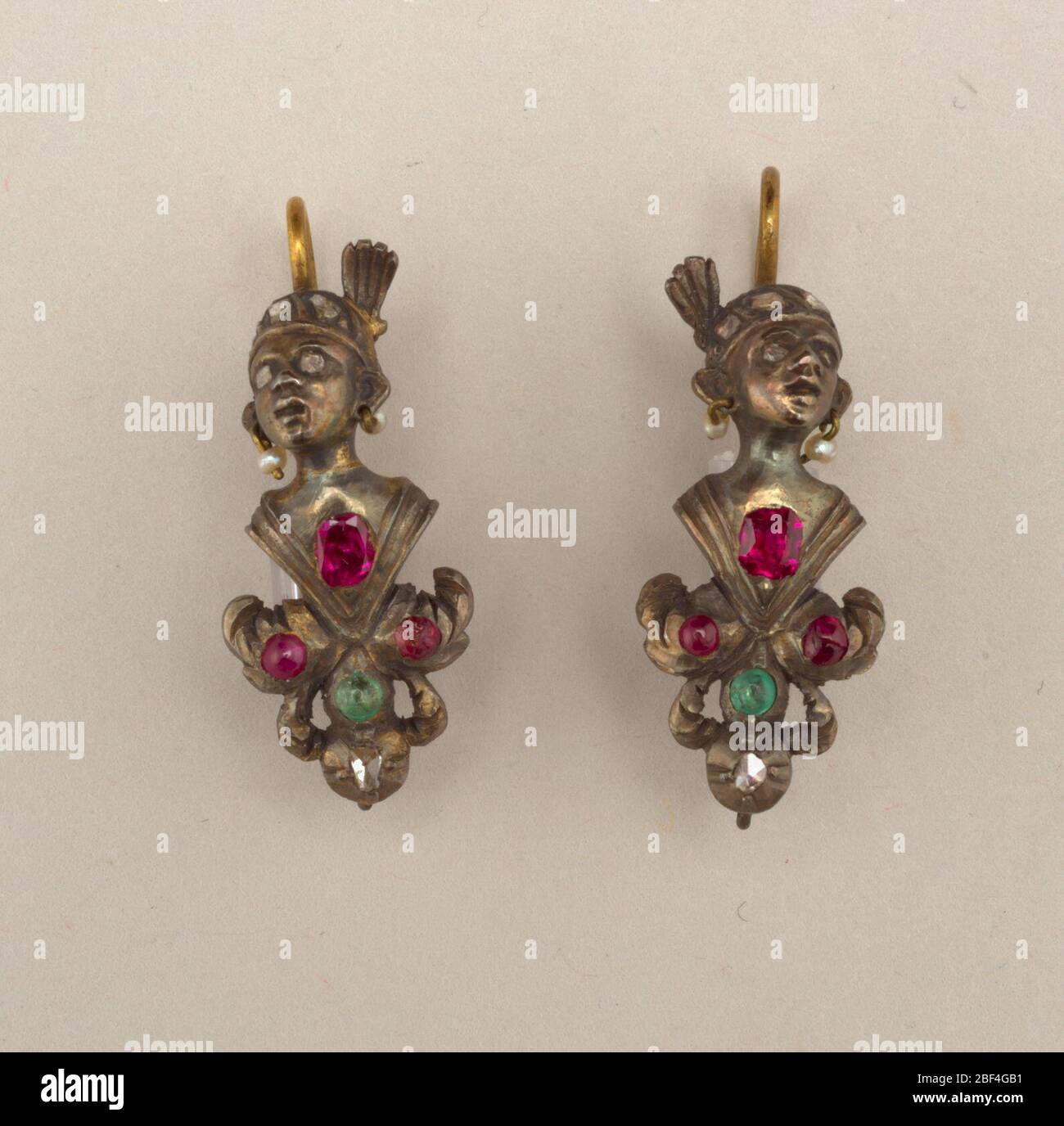 Ohrringe. A und B: Vergoldete Ohrringe in Form eines menschlichen Kopfes mit einem Turban mit Paste Diamanten und Perlen Ohrringe; am unteren Rand ein Blatt Ornament mit roten und grünen Steinen besetzt. Ring unten zeigt an, dass ein Teil fehlt. Stockfoto