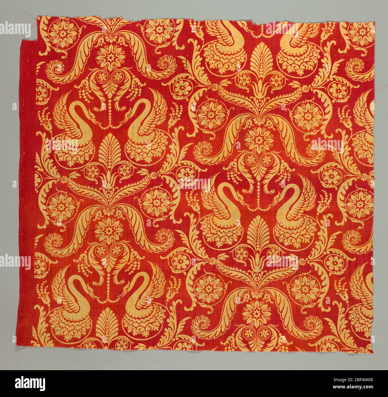 Textil. Baumwollfragment, enge Tabby-Webung, leuchtend roter Hintergrund, Design in Gelb, bedruckt (Rolle oder Teller?), Drop-Wiederholung. Design der symmetrischen Anordnung, spätklassische Einfluss. Stockfoto