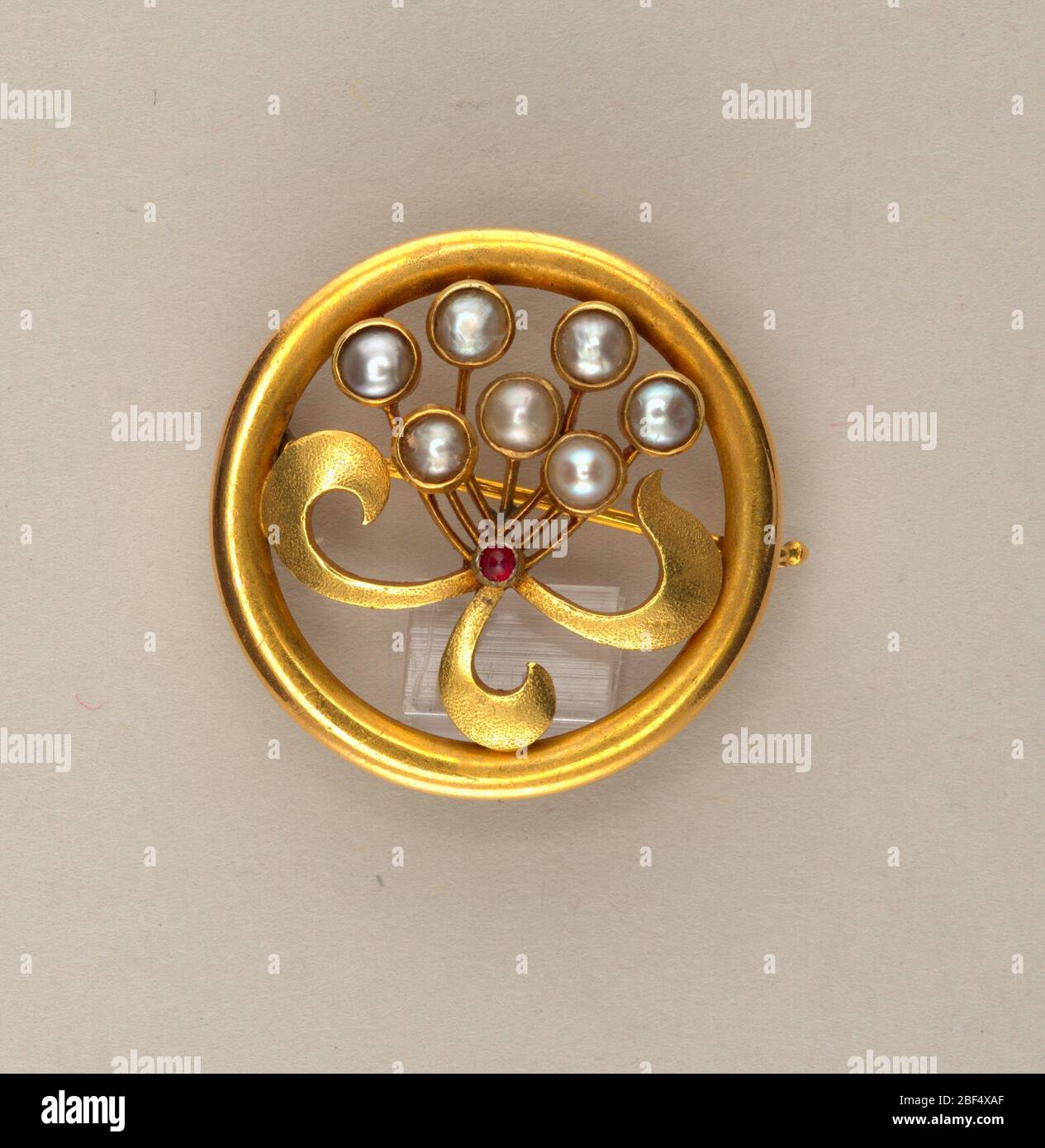 Brosche mit Perlen. Kreisförmig, mit stilisiertem Blumenstrauß aus Perlen; Rubin in der Mitte. Stockfoto