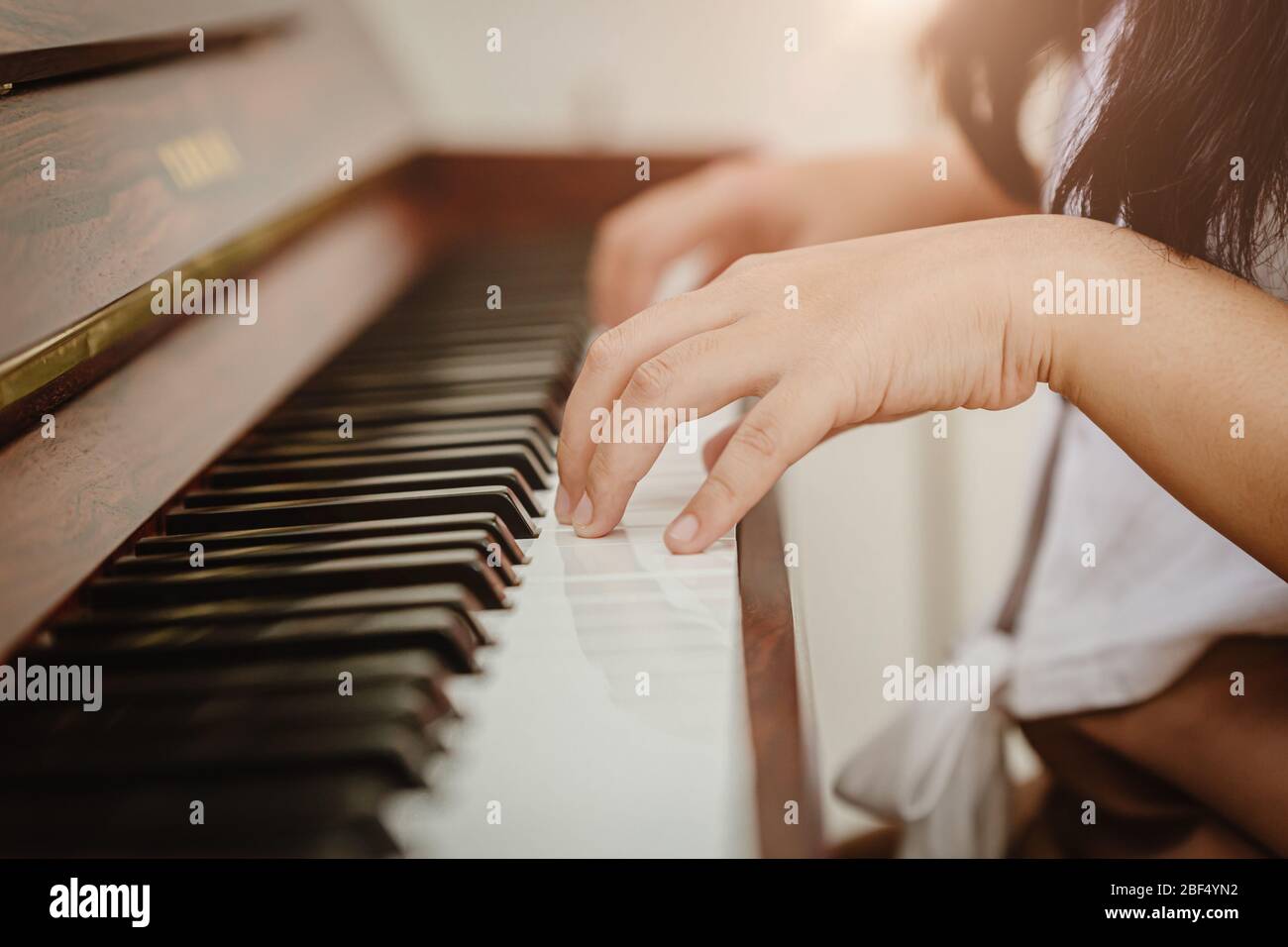 Nahaufnahme Frau Hand Klavier zu Hause Vintage colortone spielen. Stockfoto