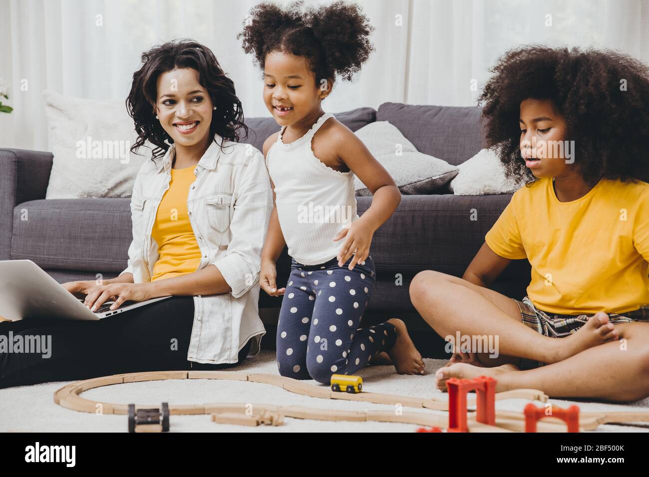 Mädchen Mutter Arbeit zu Hause mit Internet-Laptop-Effekt von Covid-19 Viruserkrankung glücklich, mit ihren Kindern zu bleiben. Stockfoto