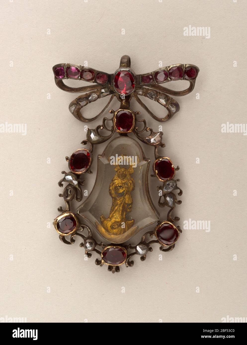 Anhänger mit Madonna. Glockenförmiger Anhänger, umgeben von Kranz aus Granaten und kleinen rosafarbenen Diamanten, an einer Schleifendraht befestigt, ebenfalls besetzt mit Granaten und Diamanten. Anhänger aus dickem Glas enthält ein Bild in Gold von Madonna und Kind. Stockfoto