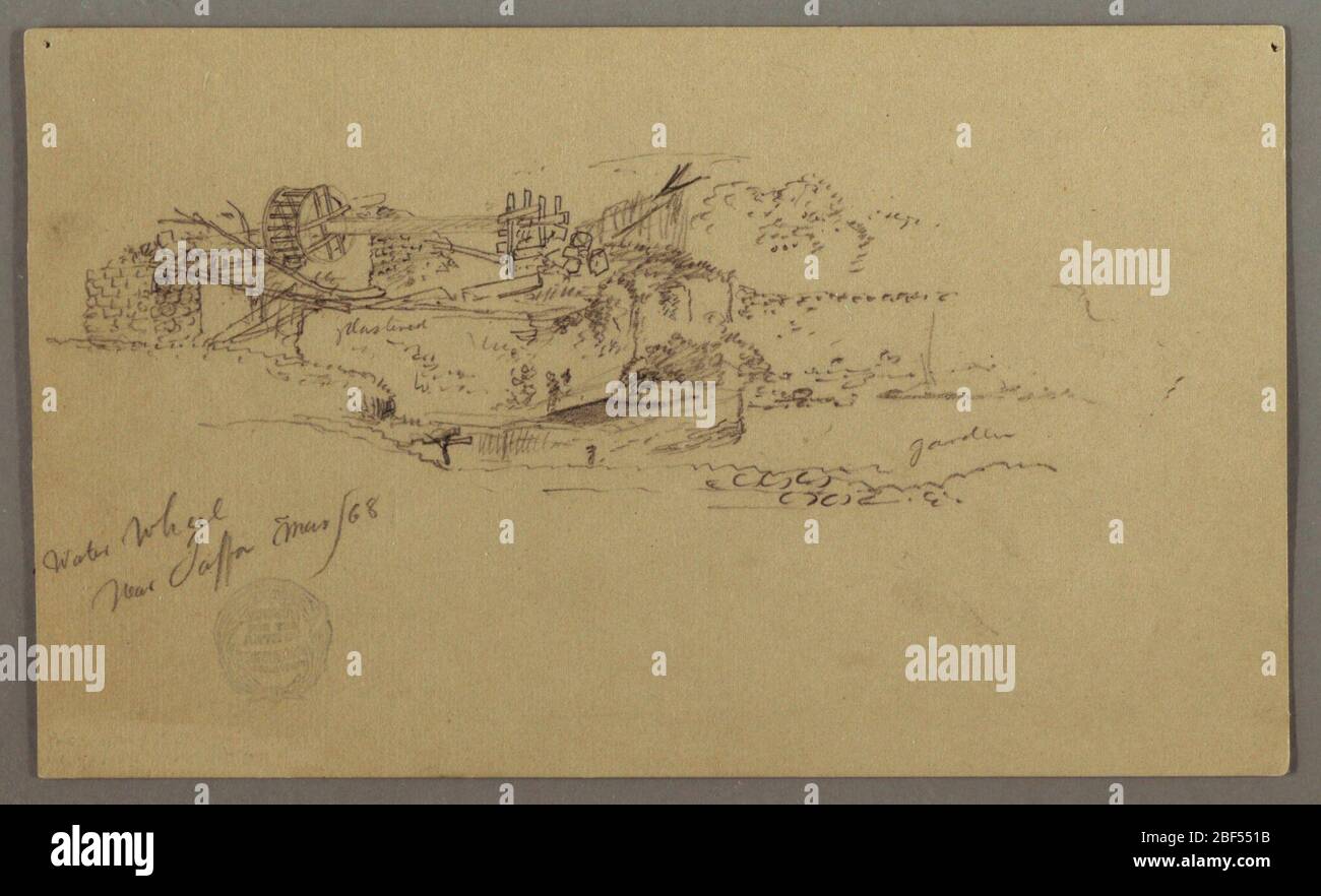 Wasserrad mit Becken im Garten Jaffa Palestine Tel Aviv Isreal. Horizontale Ansicht eines hölzernen Wasserrades mit seiner Achse, die von Wänden gestützt wird, und eines kleinen Beckens, das am Fuß der rechten Wand gezeigt wird. Stockfoto