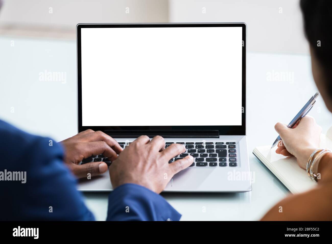 Zwei Geschäftsleute, Die An Einem Laptop Mit Leerem Bildschirm Arbeiten Stockfoto