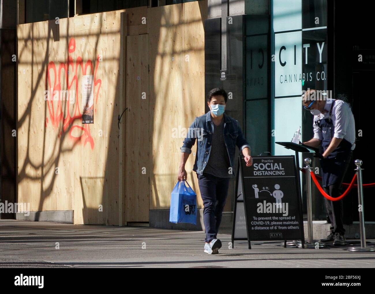 Vancouver, Kanada. April 2020. Ein Mann, der eine Gesichtsmaske trägt, kommt an einem Laden in der Innenstadt von Vancouver, Kanada, am 16. April 2020 vorbei. Der kanadische Premierminister Justin Trudeau hat am Donnerstag neue Hilfsmaßnahmen angekündigt, darunter die kommerzielle Mietzahelf und ein erweitertes Kreditprogramm, um Unternehmen bei der Bewältigung der COVID-19-Krise zu unterstützen. Das Canada Emergency Commercial Rent Assistance Programm soll kleinen Unternehmen helfen, ihre Mieten im Land für drei Monate -- zwischen April und Juni zu decken. Kredit: Liang Sen/Xinhua/Alamy Live News Stockfoto